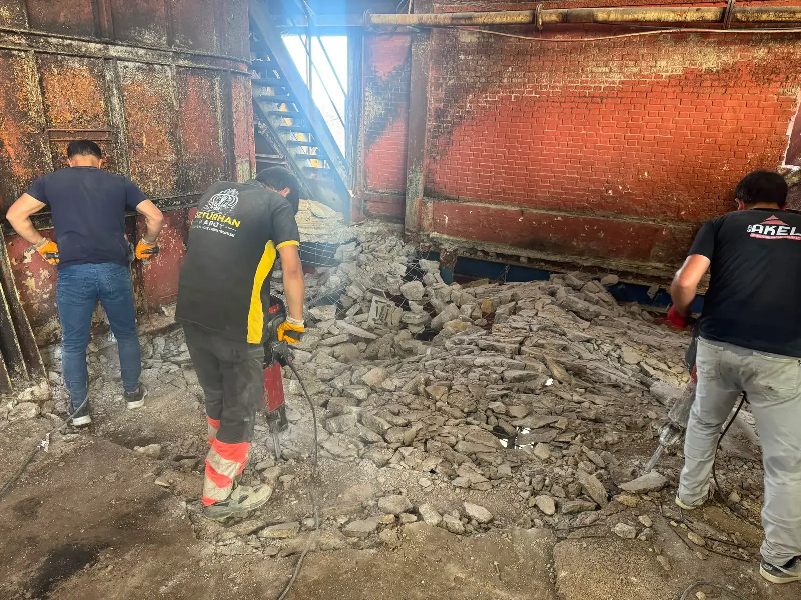 Tuğla duvarlı üretim hacminde kırıcıyla betonarme döşemeyi söken Özturhan Karot personeli